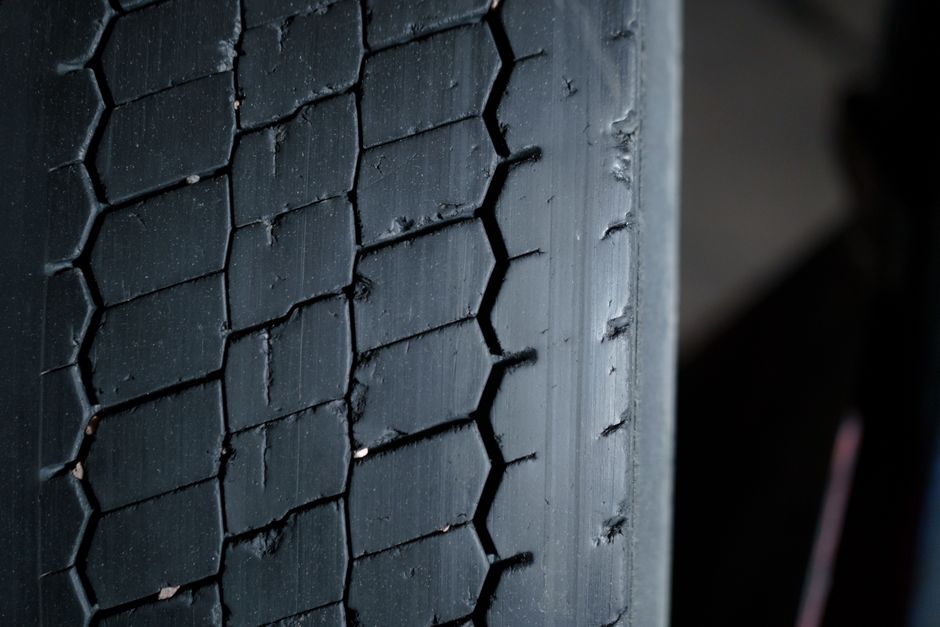 Technician checking tire tread depth and wheel alignment